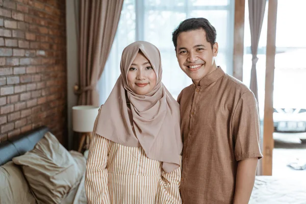 Азиатские мусульманские пары счастливо улыбаются, глядя в камеру. — стоковое фото