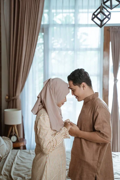 Pasangan Muslim muda tersenyum satu sama lain dahi menghadap satu sama lain dan memegang tangan — Stok Foto