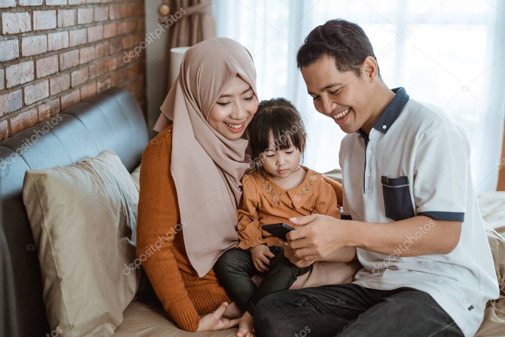 happiness of a Muslim family together when using a smartphone