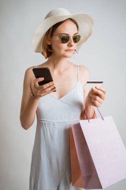 Güzel bir kadın çevrimiçi alışveriş için cep telefonu kullanıyor.