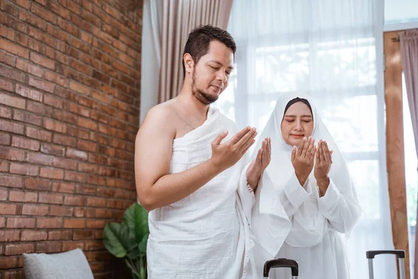 Homem e mulher muçulmanos orando de braço aberto — Fotografia de Stock