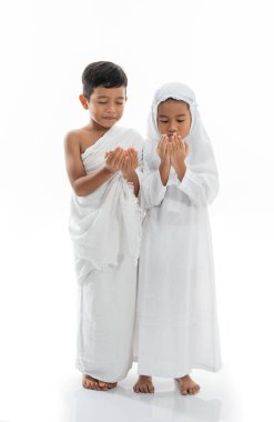 Müslüman çocuk dua ediyor ve ihram takıyor.