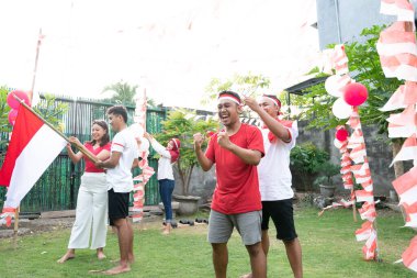 Erkekler saç bandıyla birbirlerine yardım ederler ve arkadaşları da hazırlık için kırmızı ve beyaz bayrak çekerler.