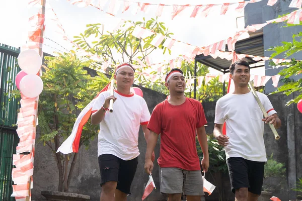 Tiga anak laki-laki berjalan sambil membawa bendera Indonesia — Stok Foto