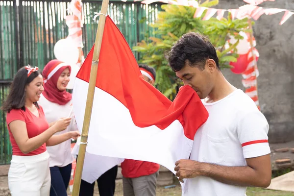 젊은 아시아인이 붉고 흰 깃발에 입을 맞추다 — 스톡 사진