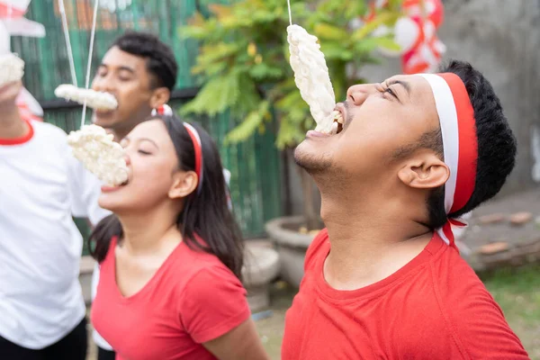 Laki-laki dan perempuan muda bersaing untuk menghabiskan kerupuk selama kontes makan cracker — Stok Foto