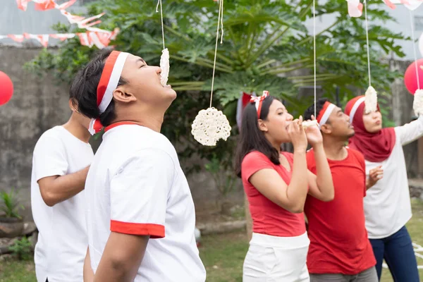 Laki-laki dan perempuan muda bersaing untuk menghabiskan kerupuk selama kontes makan cracker — Stok Foto