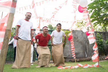 Sack yarışçıları bitiş çizgisine ulaşmak için zıplayarak birbirlerine atladılar.