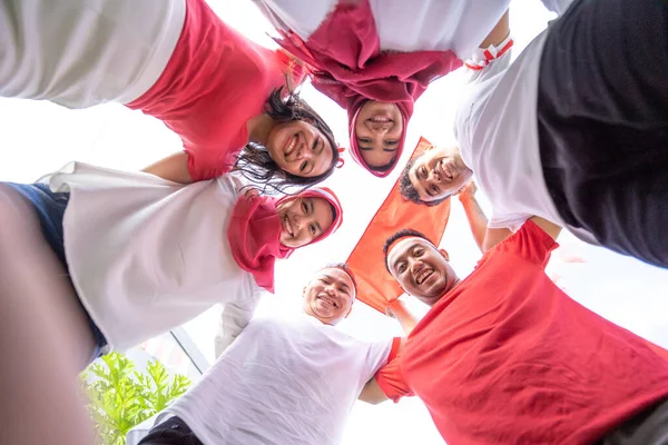 Jóvenes se abrazaron en un círculo usando atributos desde un ángulo bajo — Foto de Stock