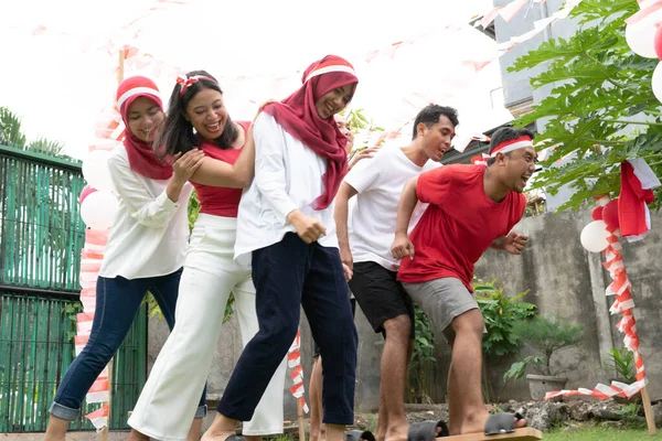 Dua kelompok peserta mencoba untuk mengikuti perlombaan bakiak tradisional pada perayaan Hari Kemerdekaan Indonesia — Stok Foto