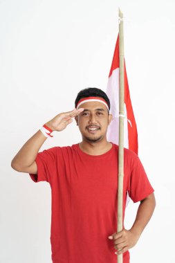 Asyalı adam elinde Endonezya bayrağı tutarken kameraya selam veriyor