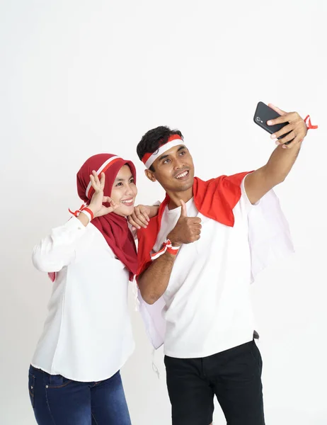 Feliz pareja con bandera indonesia tomando selfie juntos —  Fotos de Stock