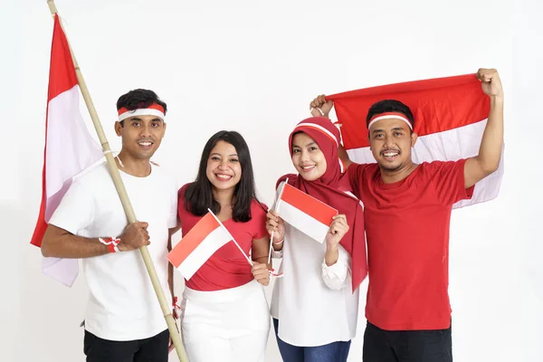 Cuatro amigos juntos sosteniendo la bandera indonesia celebrando el día de la independencia — Foto de Stock