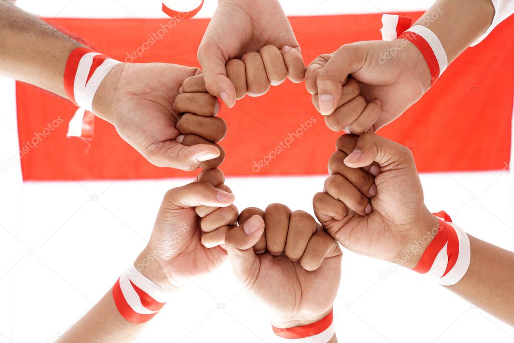 hand put together wearing indonesian red and white ribbon on a wrist