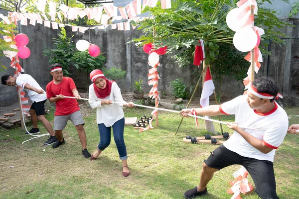Dua kelompok pemuda bersaing dalam tarik-menarik perang pada Hari Kemerdekaan Indonesia — Stok Foto