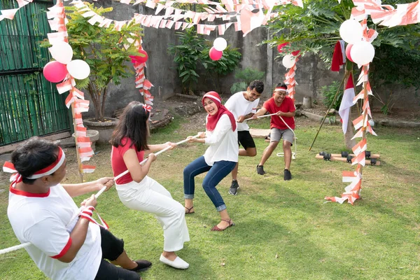 Dua kelompok pemuda bersaing dalam tarik-menarik perang pada Hari Kemerdekaan Indonesia — Stok Foto