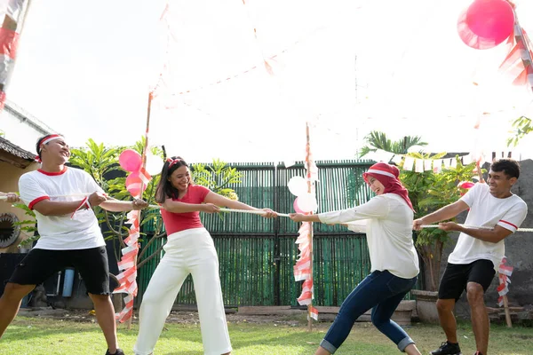 Dua kelompok pemuda bersaing dalam tarik-menarik perang pada Hari Kemerdekaan Indonesia — Stok Foto