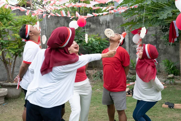 Para penonton mendukung para peserta yang makan kerupuk saat perayaan Hari Kemerdekaan Indonesia — Stok Foto