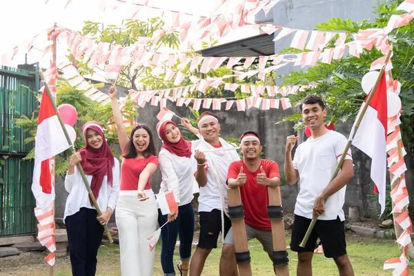 Niños y niñas asiáticos sonríen mientras portan y ondean la bandera indonesia — Foto de Stock