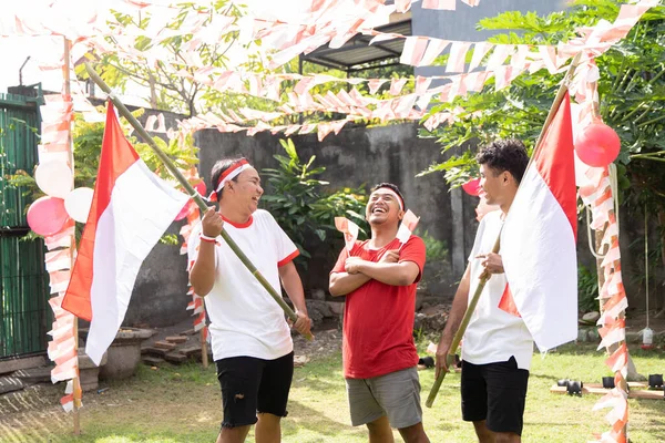 Tiga anak laki-laki sedang bercanda sambil membawa bendera Indonesia — Stok Foto