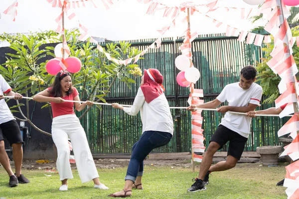 Pemuda Asia dan wanita muda yang serius ketika bergabung dengan tarik menarik permainan perang — Stok Foto