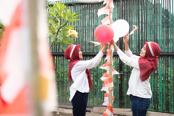 Dua gadis terselubung memasang balon dan bendera kecil dalam persiapan — Stok Foto