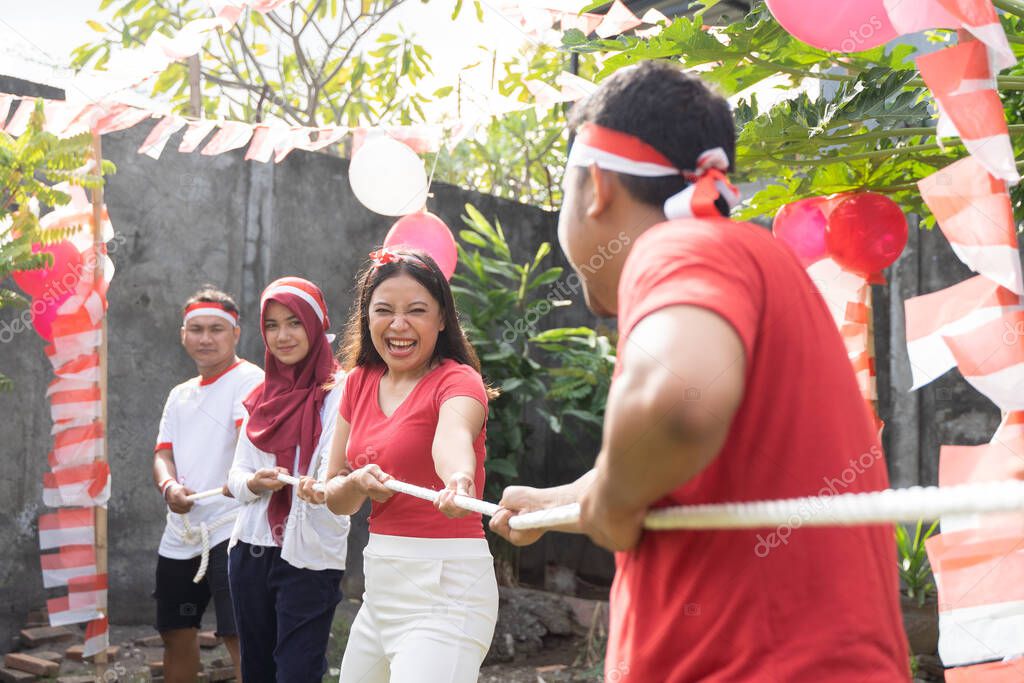 Asian young men and young women are serious when joining the tug of war game