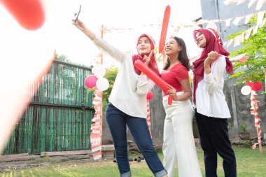 Endonezya Bağımsızlık Günü kutlamalarında konfeti ve öznitelik taşıyan bir grup kız için selfie pozu