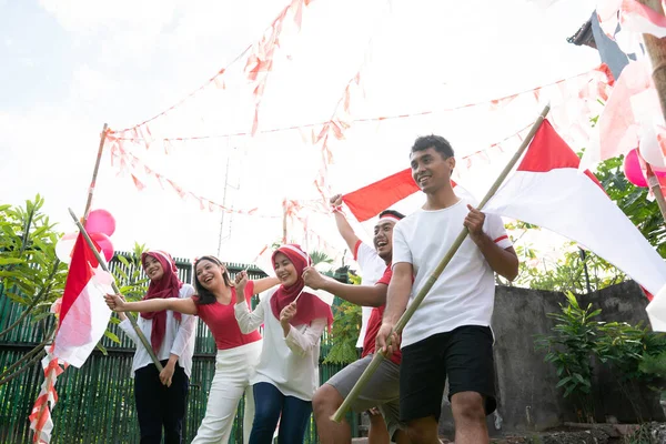 Ha kul med grupp vänner höll förberedelser för Indonesiens självständighetsdag genom att bära och bära röda och vita flaggor — Stockfoto