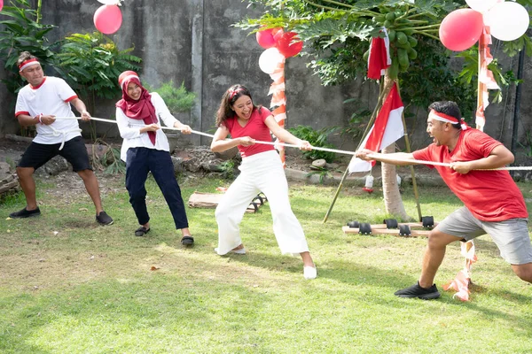 Kelompok anak-anak muda ikut serta dalam sebuah pertandingan tarik-menarik dalam perayaan hari kemerdekaan Indonesia — Stok Foto