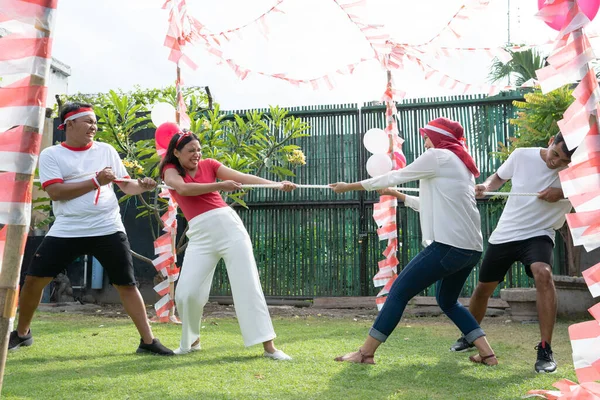 Kelompok anak-anak muda ikut serta dalam sebuah pertandingan tarik-menarik dalam perayaan hari kemerdekaan Indonesia — Stok Foto