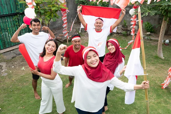 Szórakozás csoport barátok tartott előkészületek Indonézia függetlenség napja viselése és hordása piros és fehér zászlók — Stock Fotó