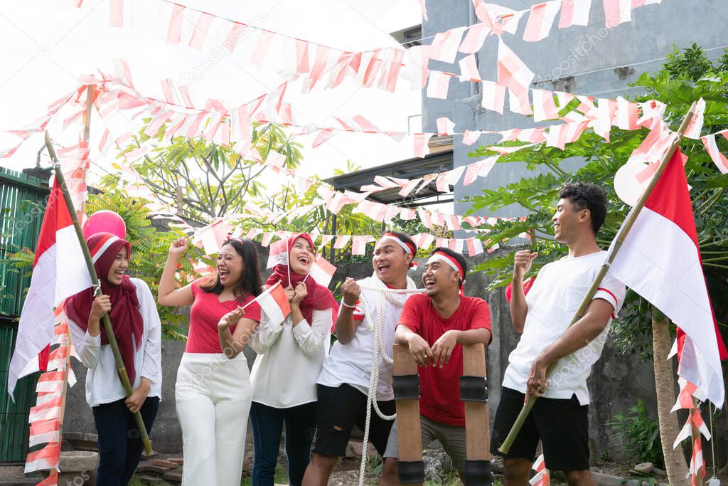 having fun of group friends held preparations for Indonesias independence day by wearing and carrying red and white flags