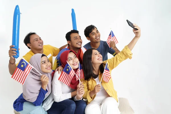 Emocionado asiático joven partidario sosteniendo malaysia bandera — Foto de Stock