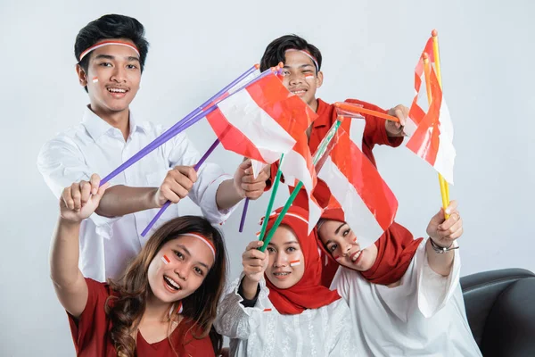 Geluk van een groep jongeren die de rood-witte attributen gebruiken — Stockfoto