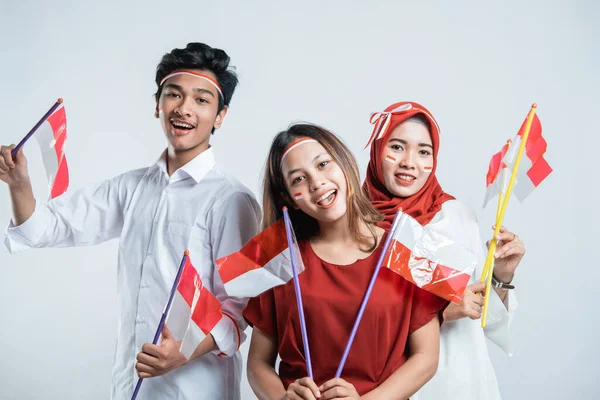Щастя групи молодих людей з використанням червоно-білих атрибутів — стокове фото