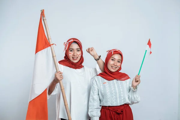 Två hijab ung kvinna leende och stå hålla indonesisk flagga med attribut — Stockfoto