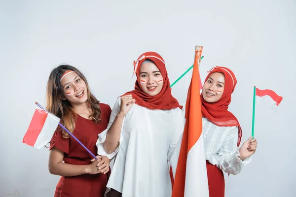 Tre flickor leende och stå hålla indonesisk flagga med attribut — Stockfoto