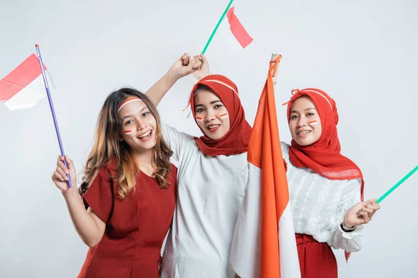 Grupp vänner leende och stå hålla indonesisk flagga med attribut — Stockfoto