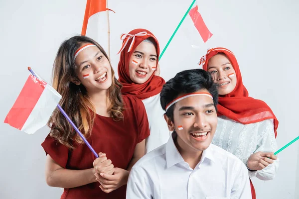 Kelompok remaja mengenakan atribut merah dan putih membawa pompom dan bendera kecil Indonesia — Stok Foto