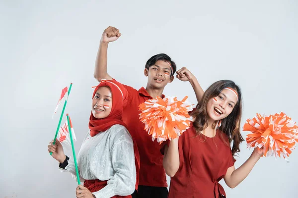 Menino stand com as mãos levantadas e duas meninas segurar pompom — Fotografia de Stock