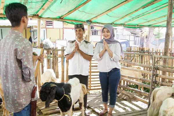 Muslim pasangan di peternakan hewan membeli kambing — Stok Foto