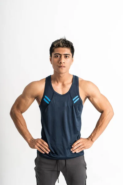 Asiatischer muskulöser Mann in Sportbekleidung blickt mit den Händen an der Taille nach vorne in die Kamera — Stockfoto