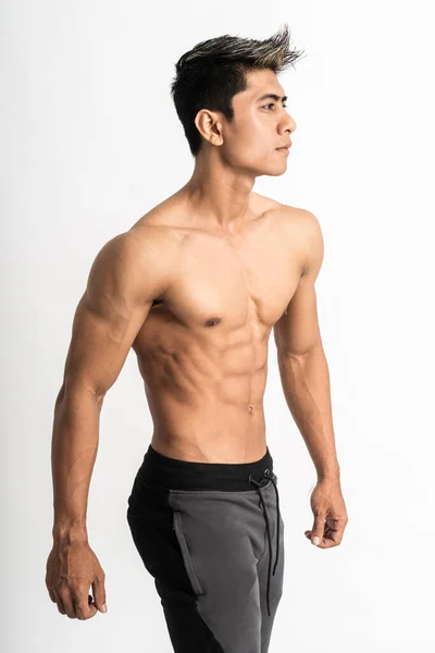 Metade corpo imagem de asiático jovem homem mostrando um lado muscular barriga stand enfrentando lado — Fotografia de Stock