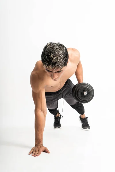 Vista del ángulo frontal del hombre muscular sin ropa hacer ejercicios de empuje hacia arriba con una mancuerna en una mano —  Fotos de Stock