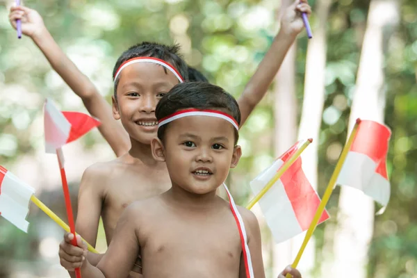 Close-up van kinderen gezicht bij het vasthouden van kleine rode en witte vlag en geheven samen — Stockfoto