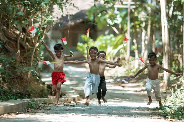 Plezier groep van kinderen lopen zonder kleren jagen elkaar wanneer het houden van kleine de rode en witte vlag — Stockfoto