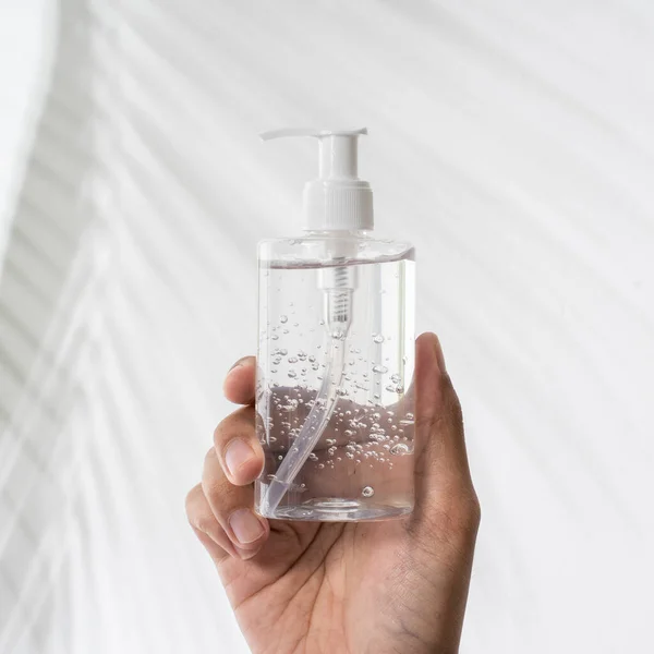 Hand holding plastic bottle hand sanitizer mockup — Stock Photo, Image