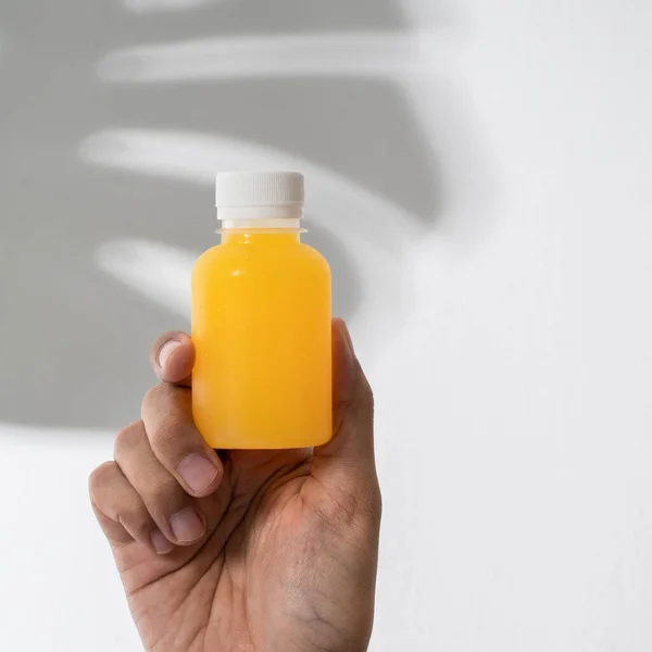 Ręczne trzymanie plastikowej butelki produktu makieta — Zdjęcie stockowe