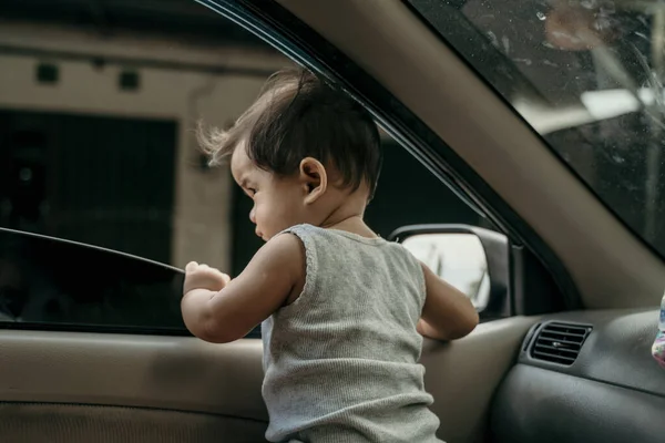 Маленький ребенок стоять в машине, когда окна открыты — стоковое фото